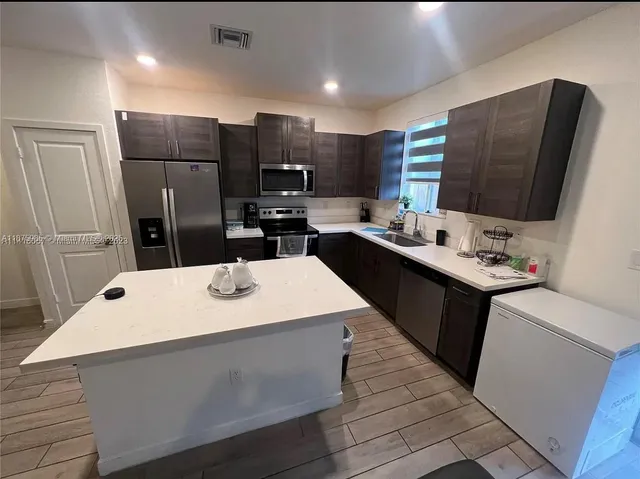 a kitchen with a sink a counter top space and stainless steel appliances