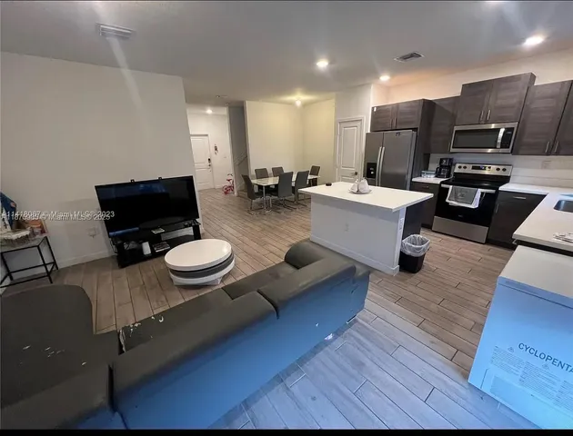 a living room with furniture and kitchen view
