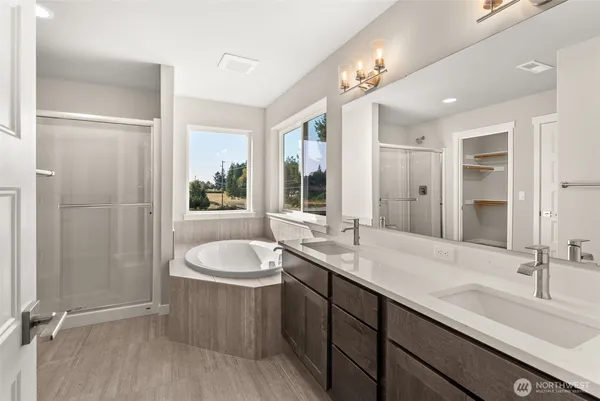 a spacious bathroom with a tub sink and mirror