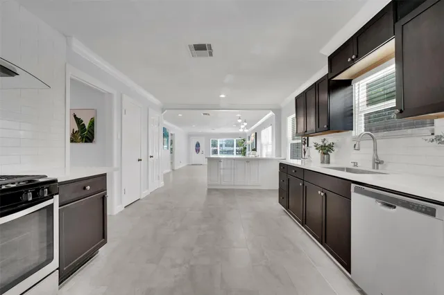 a large kitchen with stainless steel appliances granite countertop a lot of counter space and wooden floor