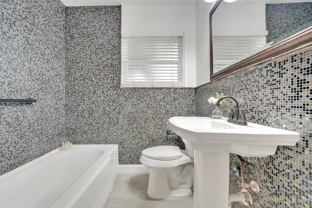 a bathroom with a sink a toilet and bathtub