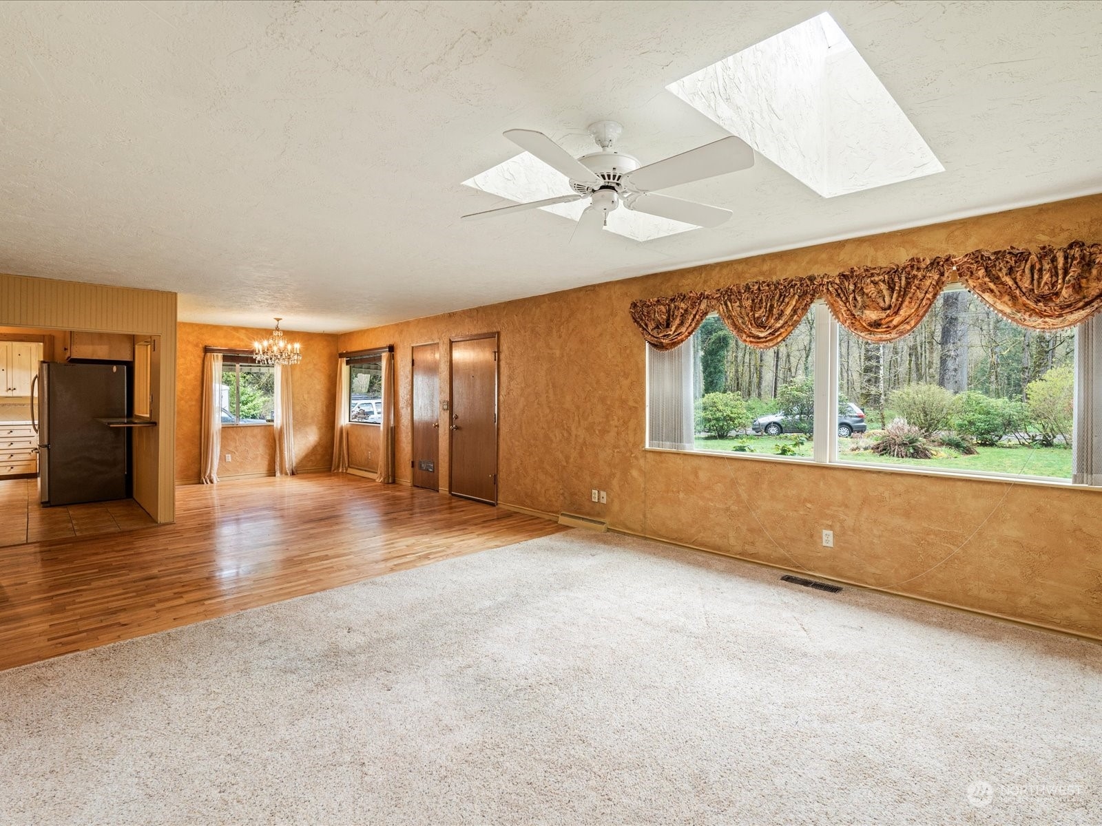16446 Southeast Jones Road Renton, WA 98058 - Photo 4 of 40 an empty room with wooden floor and windows