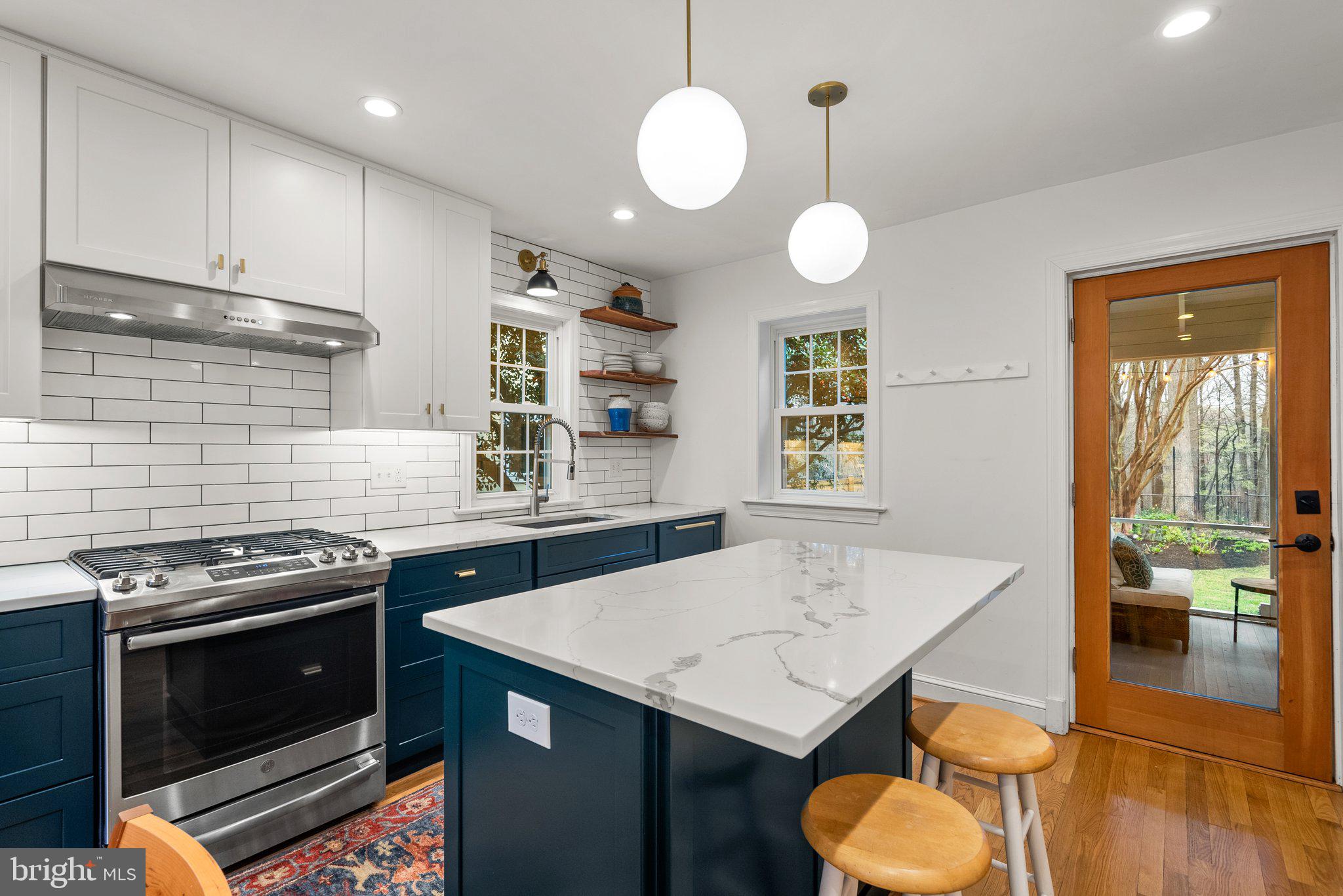 10115 Big Rock Road Silver Spring, MD 20901 - Photo 14 of 43 a kitchen with a stove a kitchen island a stove cabinets a dining table and chairs