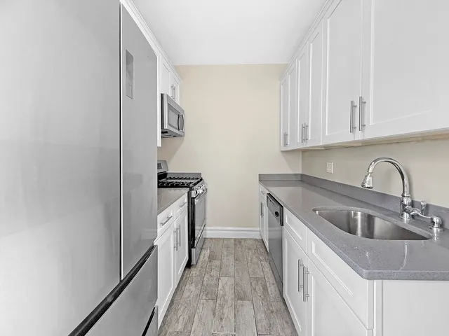a kitchen with granite countertop a refrigerator and a sink