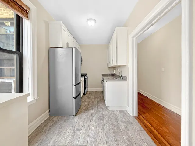 a kitchen with a refrigerator sink stove and cabinets