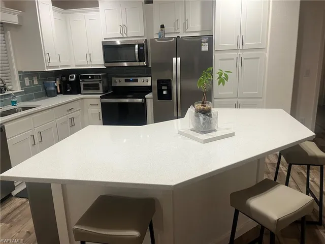 a kitchen with a table chairs and refrigerator