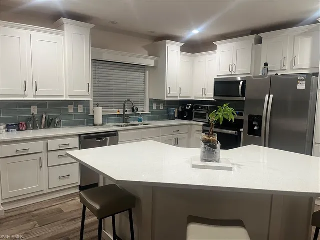 a kitchen with stainless steel appliances a sink and cabinets