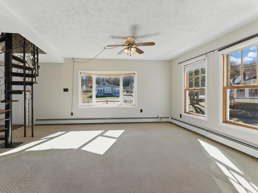 90 Union Road Wales, MA 01081 - Photo 15 of 40 an empty room with windows and chandelier fan