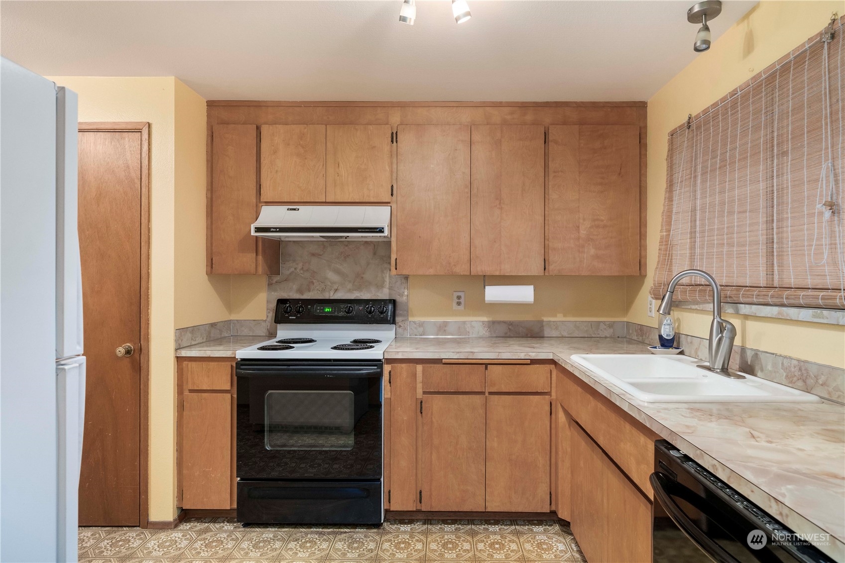 903 Southwest 104th Street Seattle, WA 98146 - Photo 11 of 26 a kitchen with a sink stove and cabinets