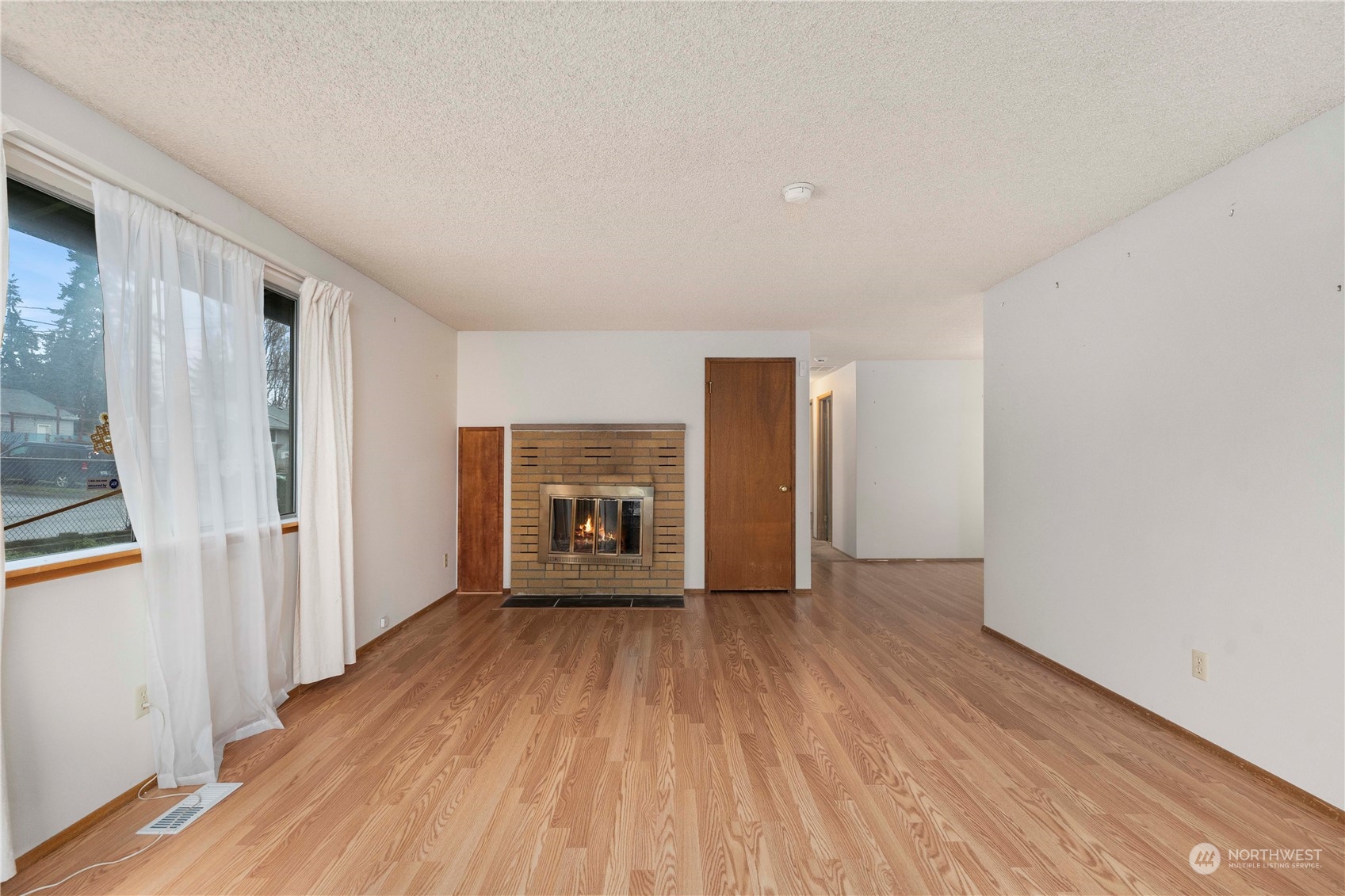 903 Southwest 104th Street Seattle, WA 98146 - Photo 6 of 26 a view of empty room with wooden floor and fireplace