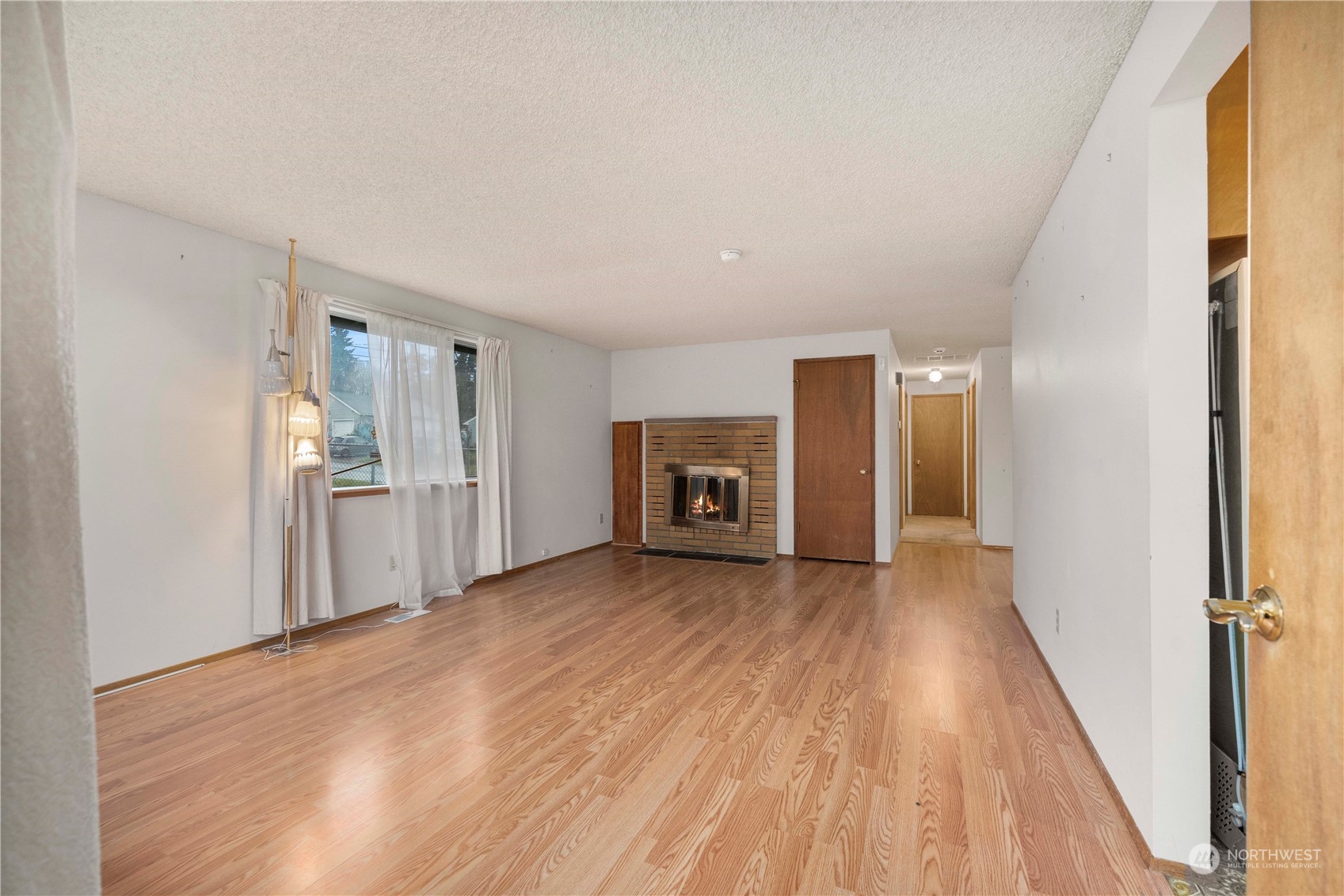 903 Southwest 104th Street Seattle, WA 98146 - Photo 7 of 26 a view of a livingroom with wooden floor and kitchen space