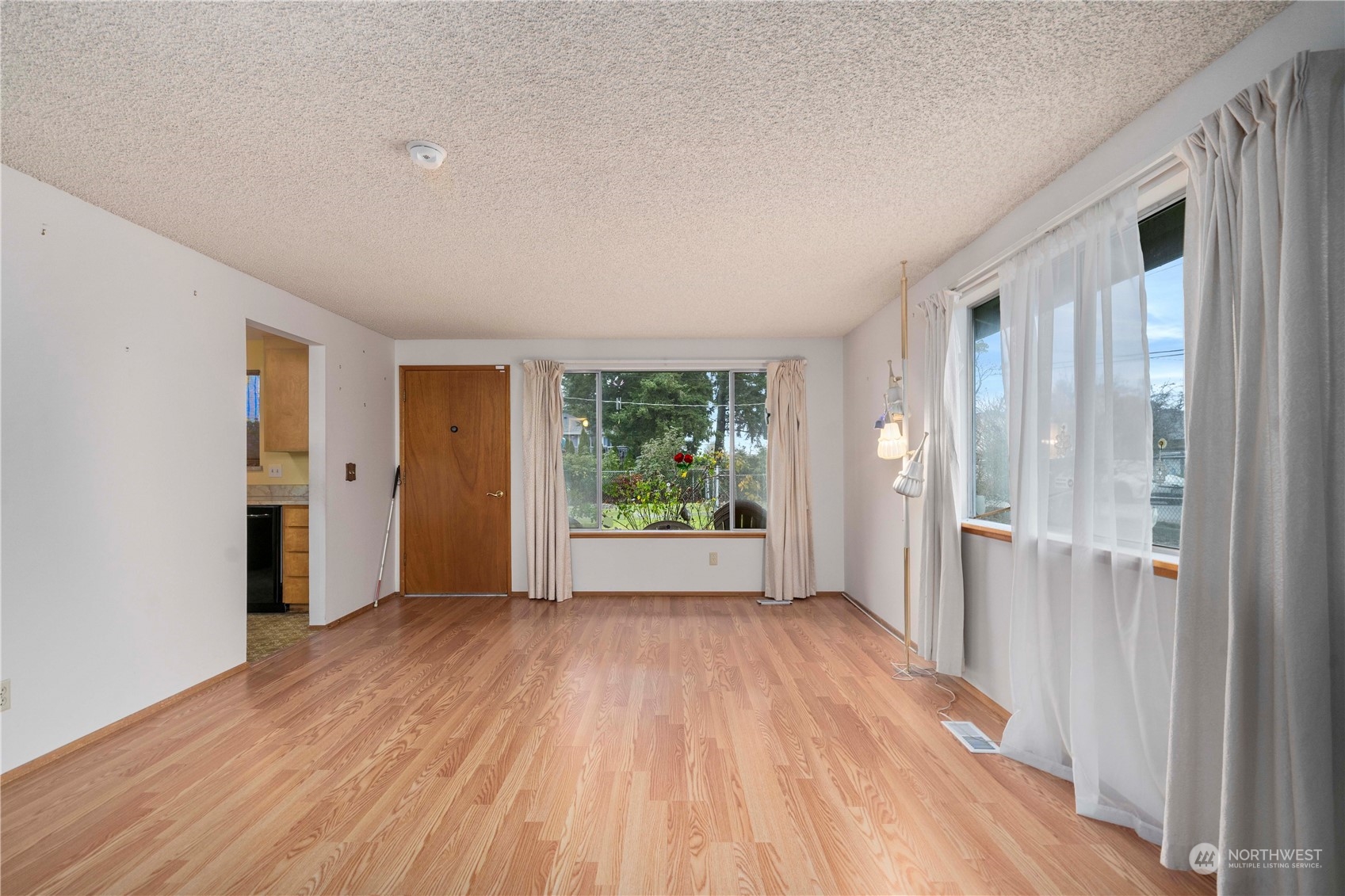 903 Southwest 104th Street Seattle, WA 98146 - Photo 8 of 26 a view of an empty room with wooden floor and a window