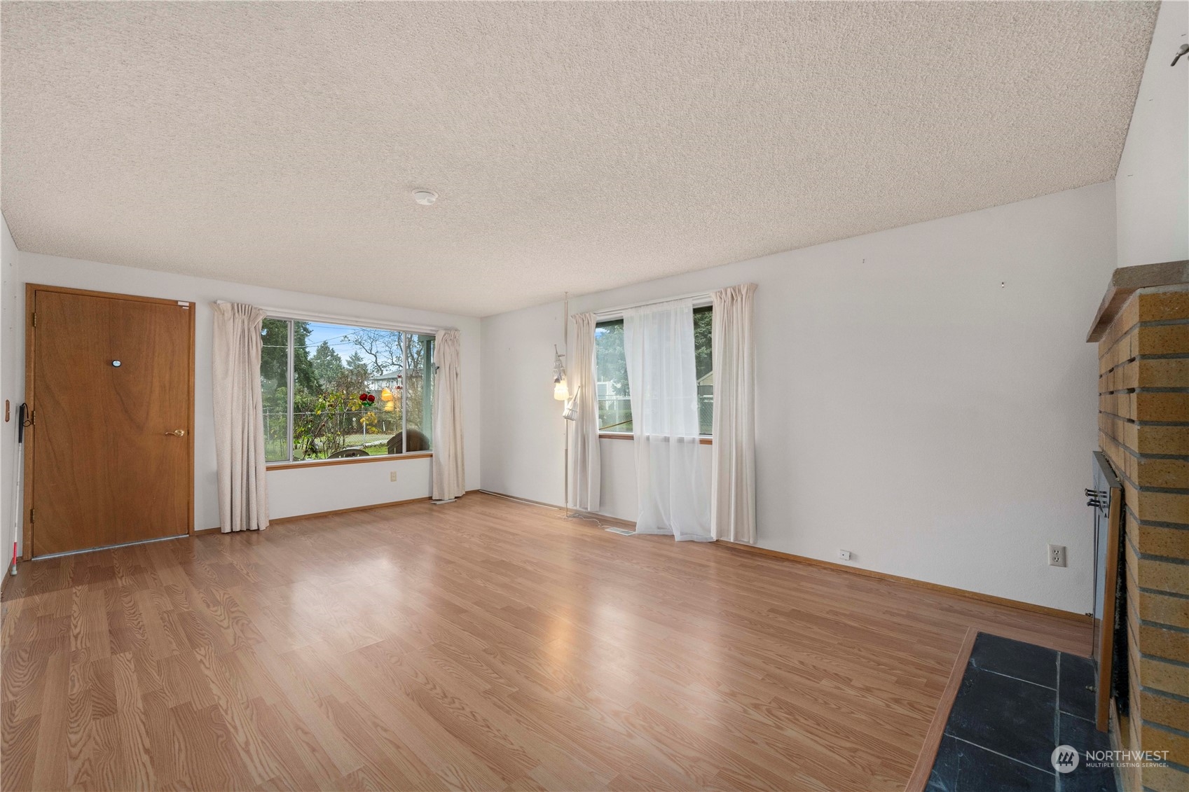 903 Southwest 104th Street Seattle, WA 98146 - Photo 9 of 26 a view of an empty room with wooden floor and a window
