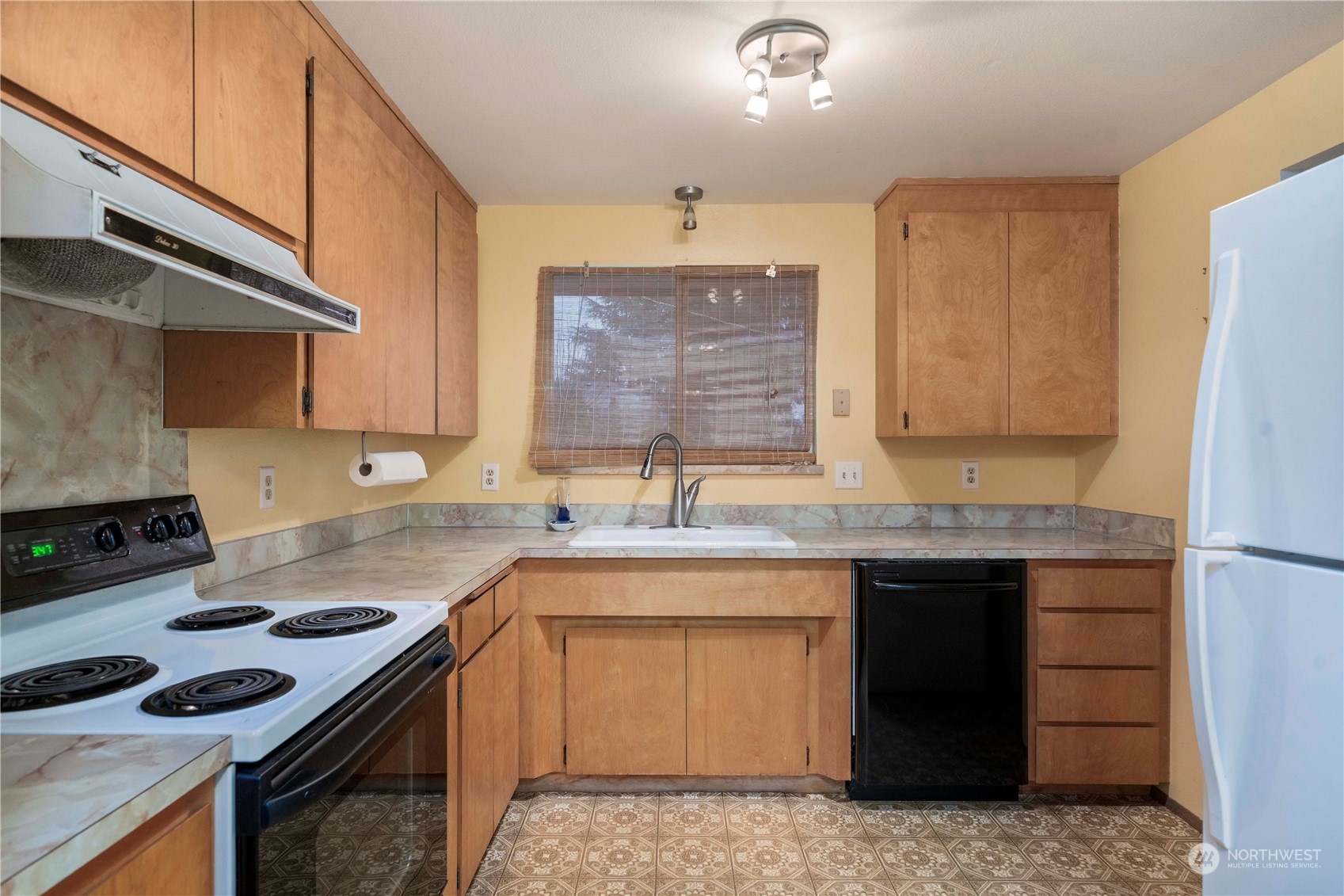 903 Southwest 104th Street Seattle, WA 98146 - Photo 10 of 26 a kitchen with a sink stove and cabinets