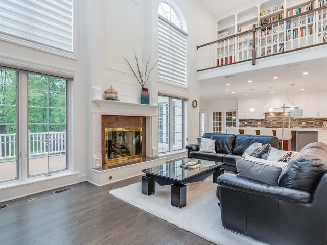 a living room with furniture a fireplace and a large window