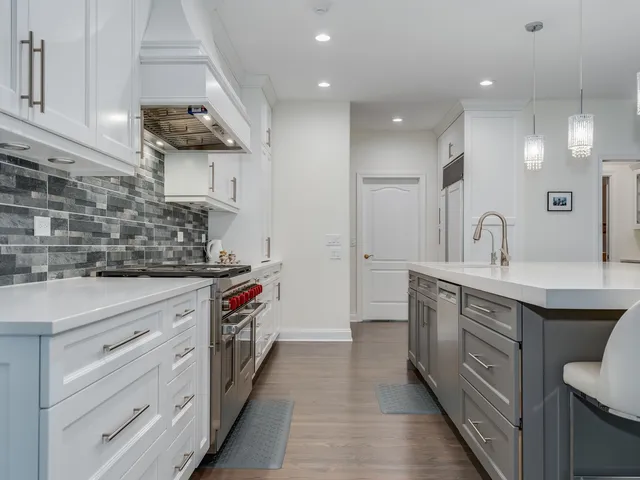 a kitchen with kitchen island granite countertop a sink cabinets and wooden floor