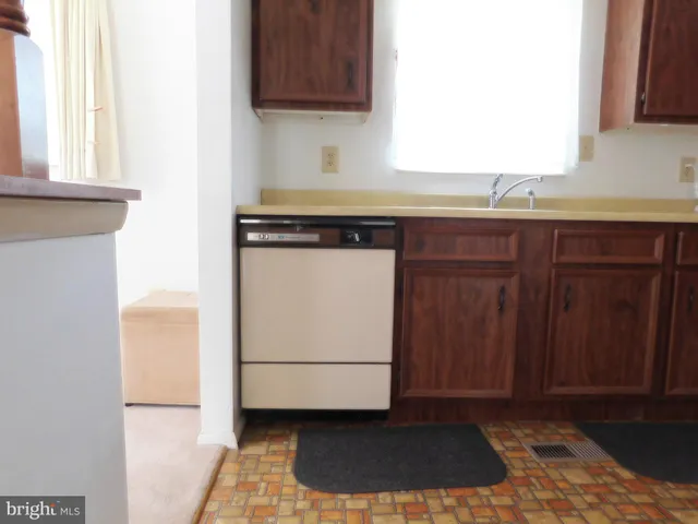 a kitchen with a sink cabinets and a window