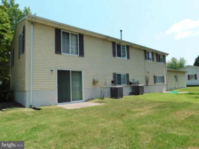 a view of an house with backyard and tree