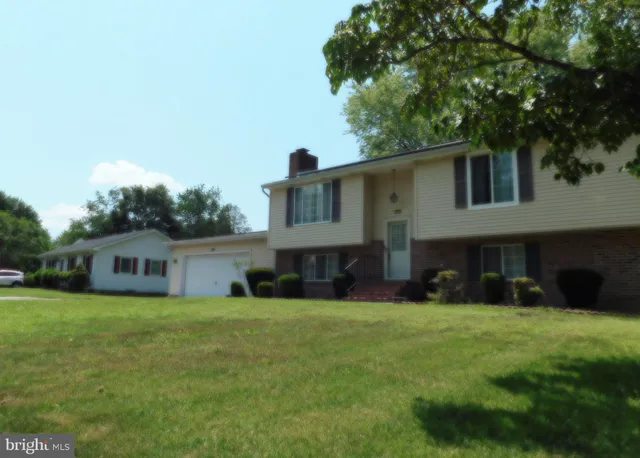 a view of a house with a yard and sitting area