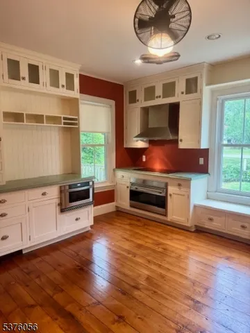 a kitchen with stainless steel appliances a stove and a wooden floor