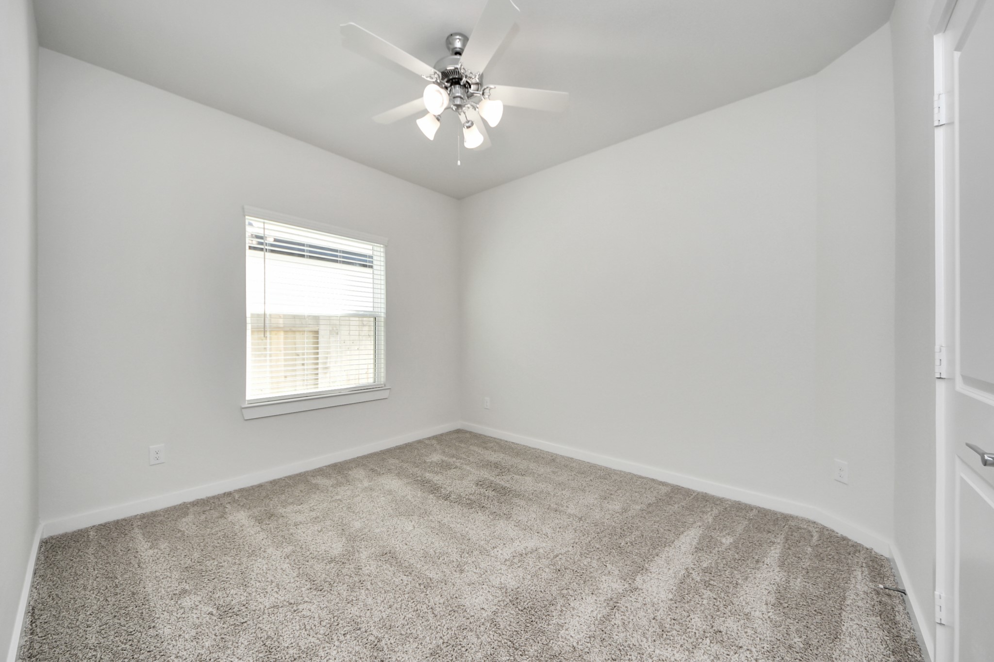 21507 Indigo Ruth Drive Spring, TX 77379 - Photo 17 of 33 an empty room with a chandelier fan and windows