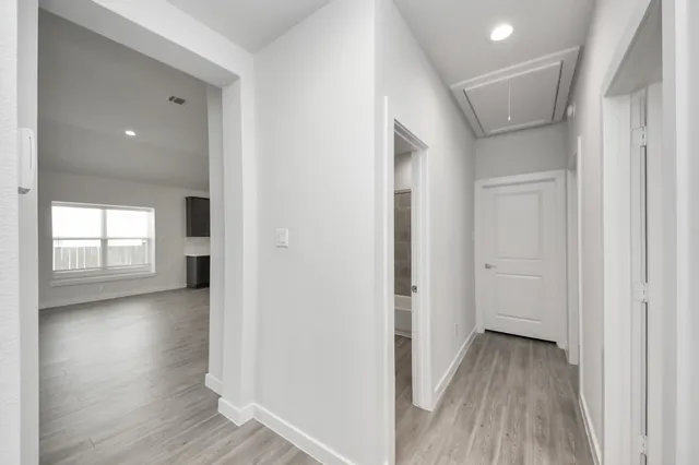 an empty room with chandelier fan and windows