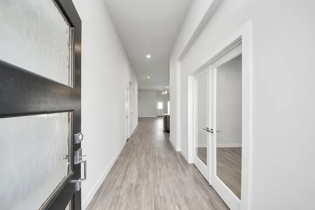 a view of a hallway with wooden floor