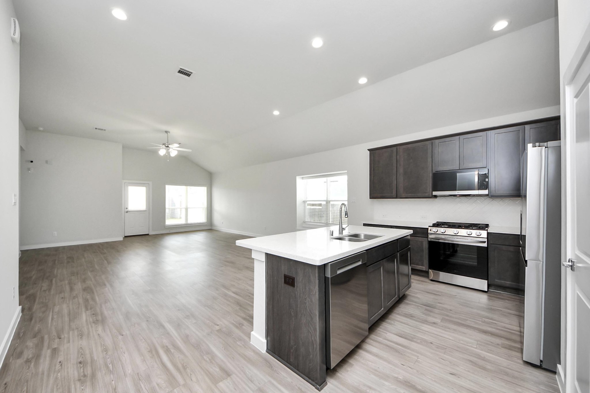 21507 Indigo Ruth Drive Spring, TX 77379 - Photo 4 of 33 a kitchen with stainless steel appliances granite countertop a sink a stove top oven a wooden floors