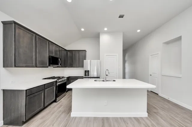 a kitchen with a sink and a stove top oven
