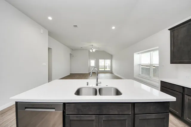 a kitchen with a sink a window and stainless steel appliances
