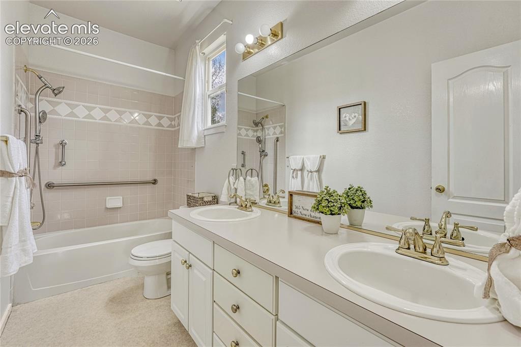 7285 Julynn Road Colorado Springs, CO 80919 - Photo 24 of 45 a bathroom with a double vanity sink toilet mirror and shower