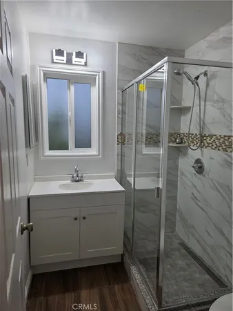 a bathroom with a shower sink and mirror