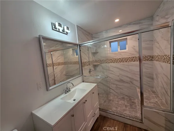a bathroom with a shower sink and mirror