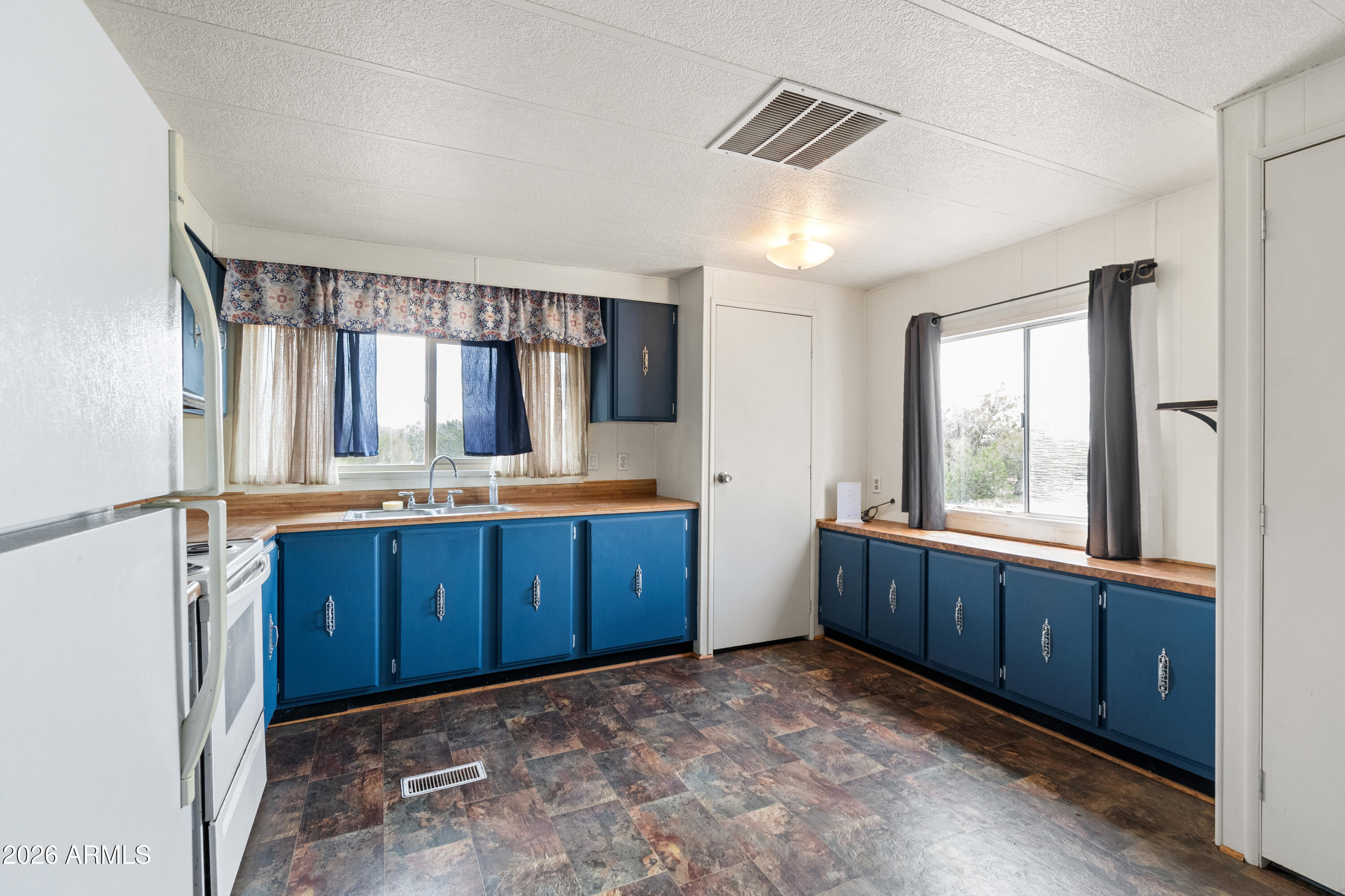 2385 County Line Circle Ash Fork, AZ 86320 - Photo 4 of 35 a kitchen with wooden cabinets and sink