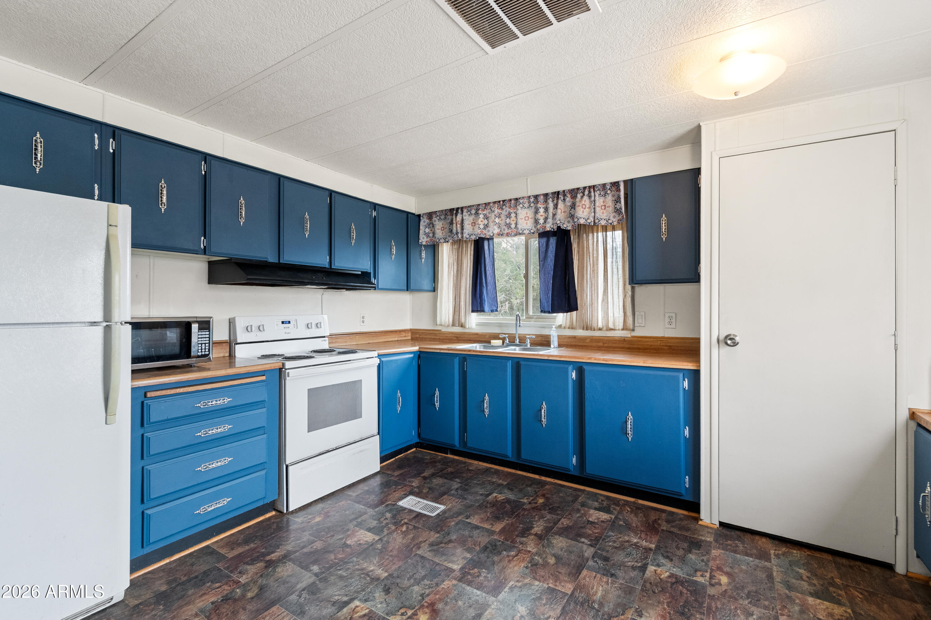 2385 County Line Circle Ash Fork, AZ 86320 - Photo 5 of 35 a kitchen with stainless steel appliances granite countertop a refrigerator and a stove top oven