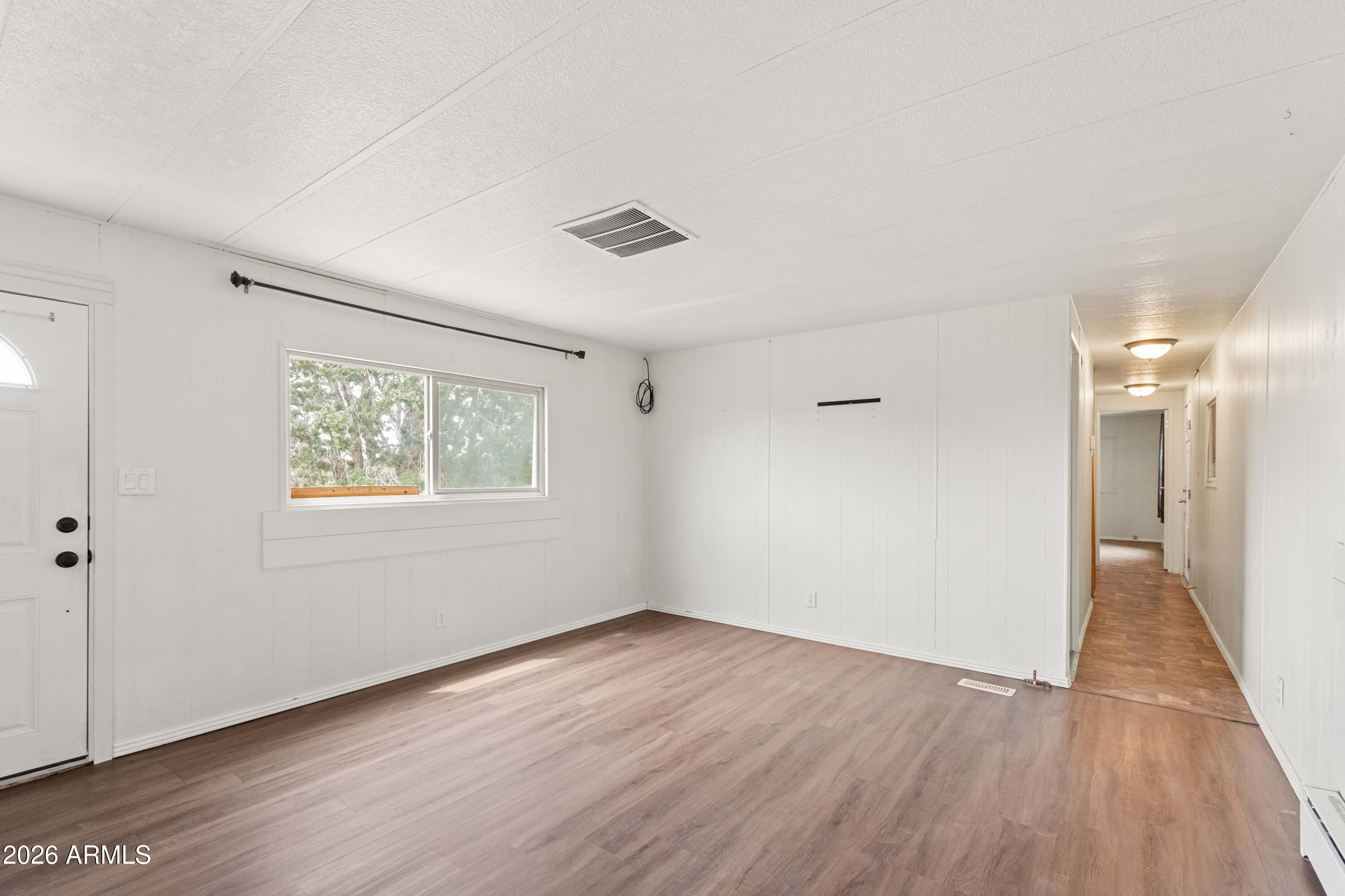 2385 County Line Circle Ash Fork, AZ 86320 - Photo 9 of 35 a view of an empty room with wooden floor and a window