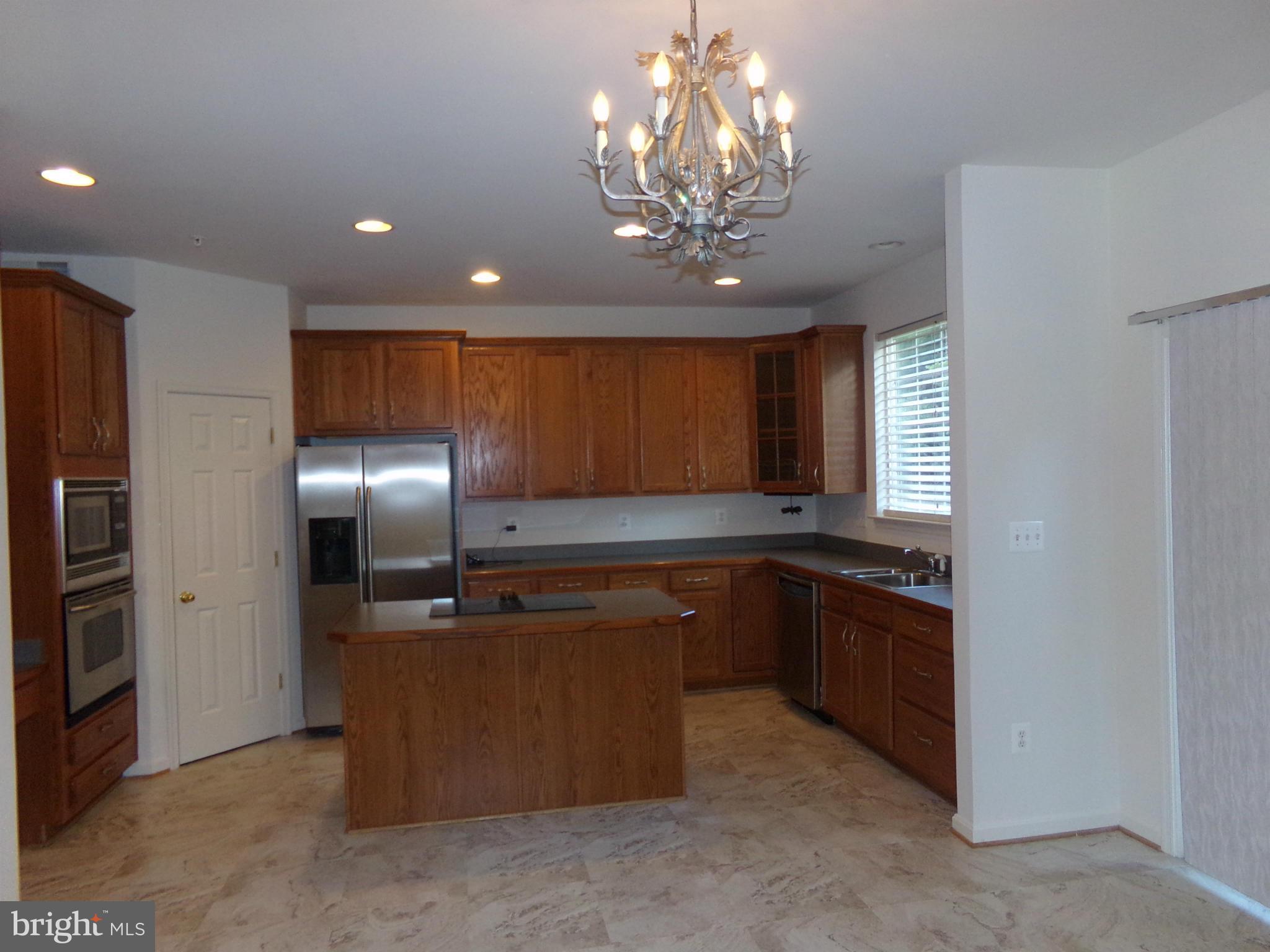 9834 Farm Pond Road Laurel, MD 20708 - Photo 13 of 30 a kitchen with stainless steel appliances granite countertop a refrigerator and a sink