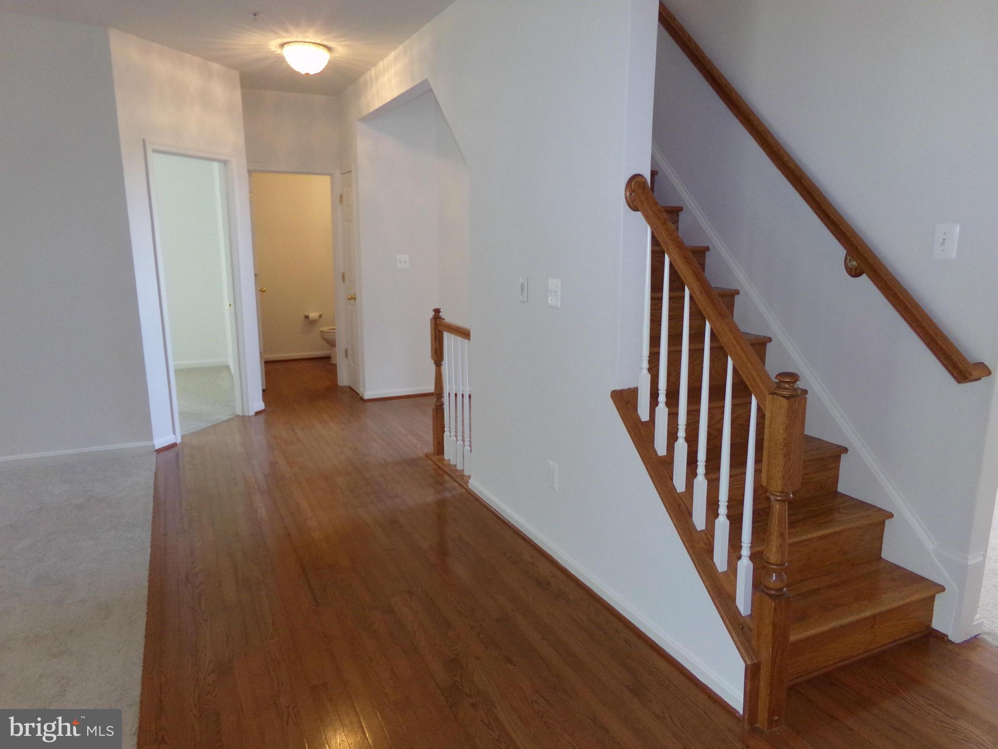 9834 Farm Pond Road Laurel, MD 20708 - Photo 21 of 30 a view of a hallway with wooden floor and staircase
