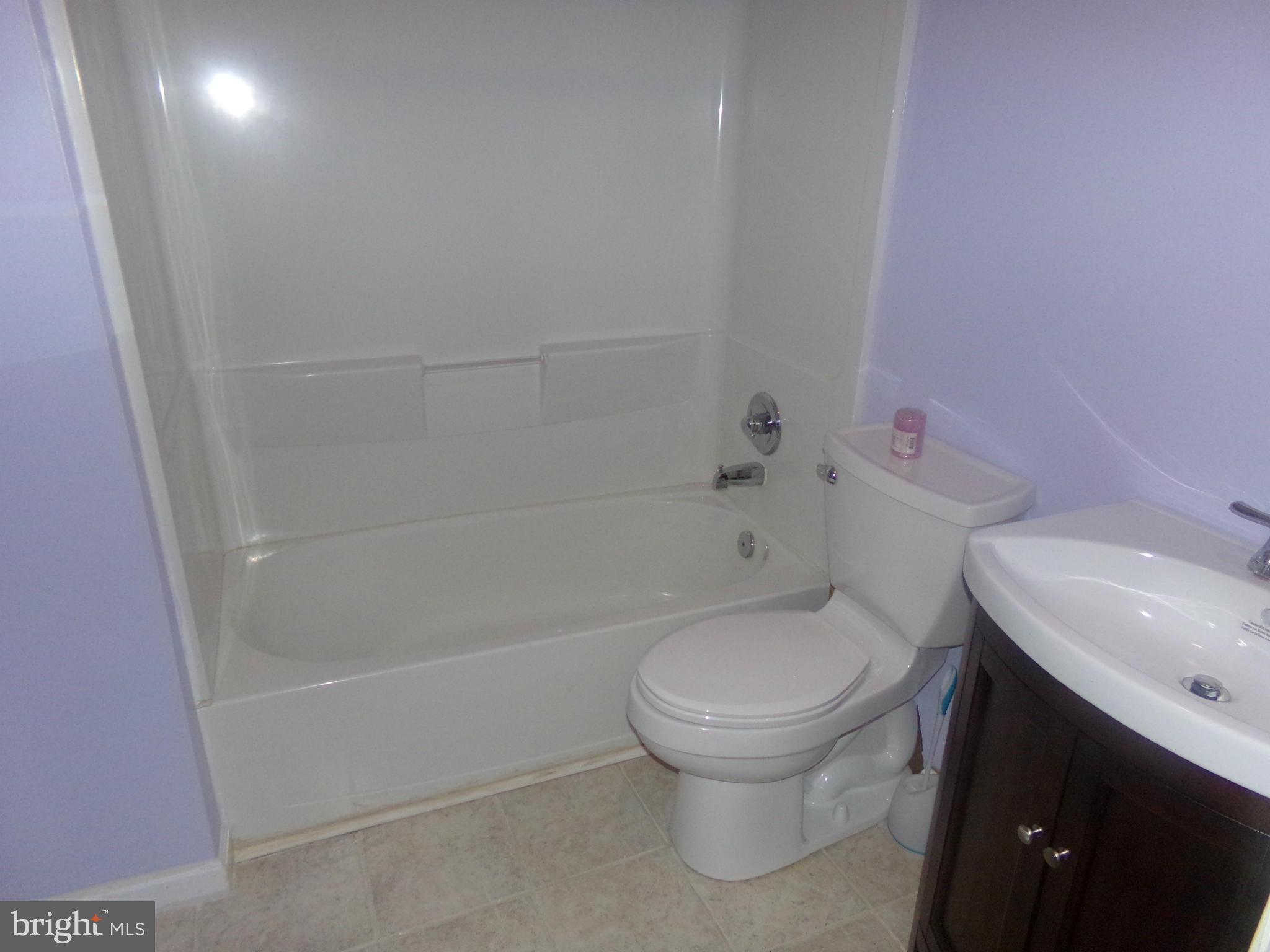 9834 Farm Pond Road Laurel, MD 20708 - Photo 28 of 30 a white toilet sitting next to a bath tub