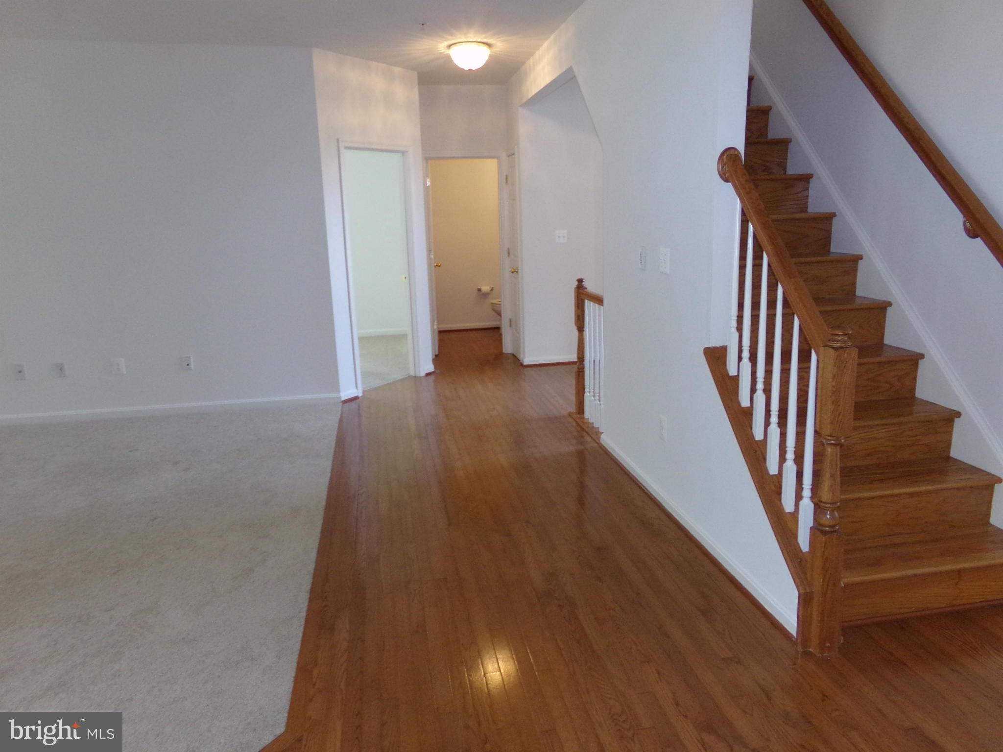 9834 Farm Pond Road Laurel, MD 20708 - Photo 10 of 30 a view of a hallway with wooden floor and stairs