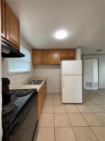 a kitchen with a stove a refrigerator and a cabinets