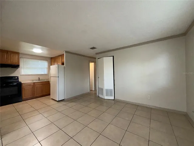 a kitchen that has a sink a refrigerator and cabinets