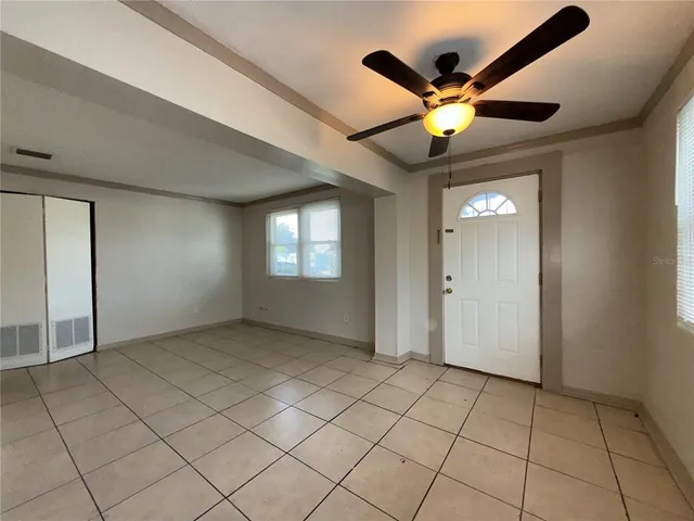 an empty room with closet and ceiling fan