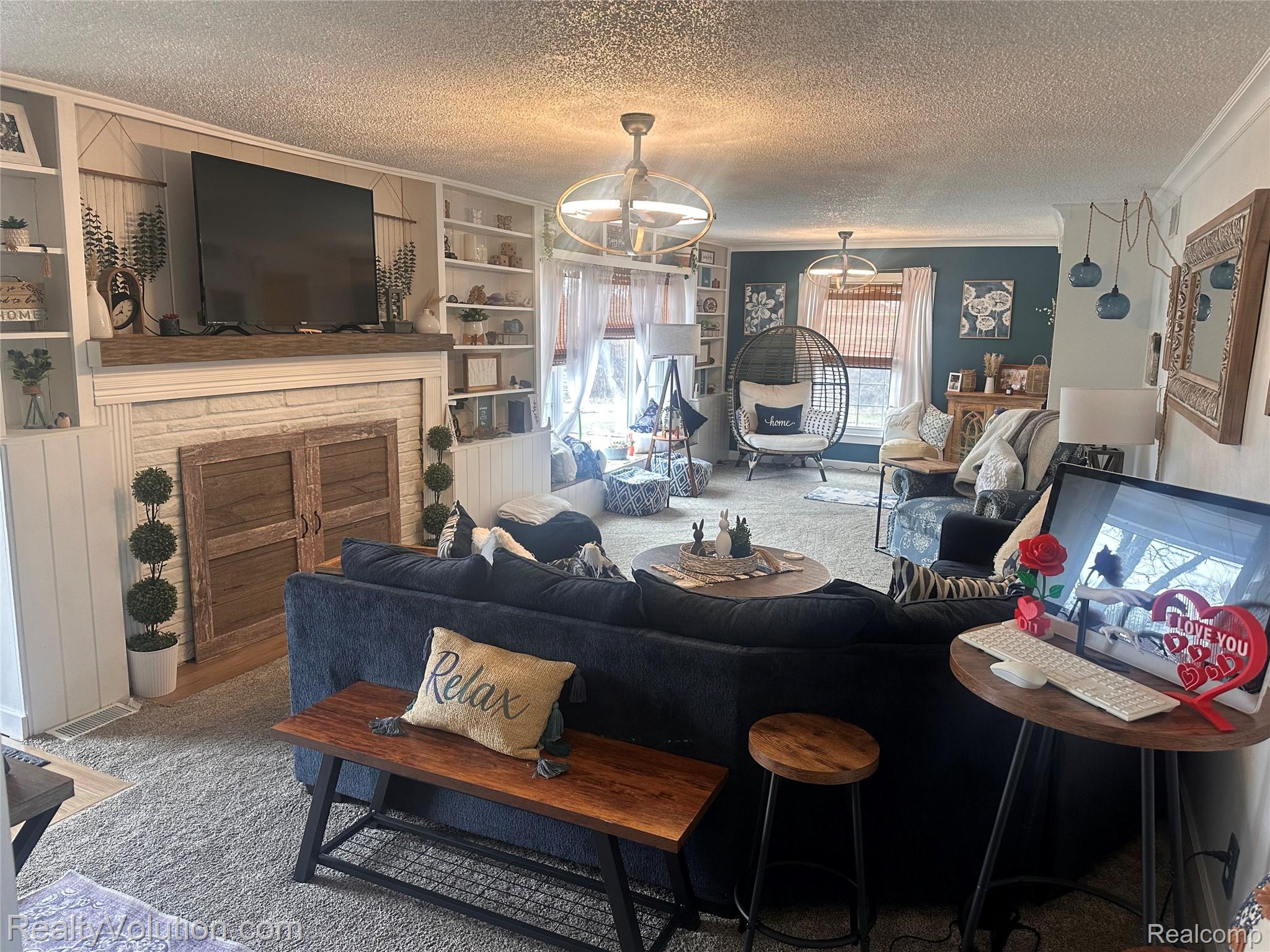 3034 West Oregon Road Lapeer, MI 48446 - Photo 5 of 29 Living area featuring a textured ceiling, crown molding, a fireplace, built in shelves, and carpet flooring