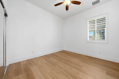 an empty room with a window and a ceiling fan