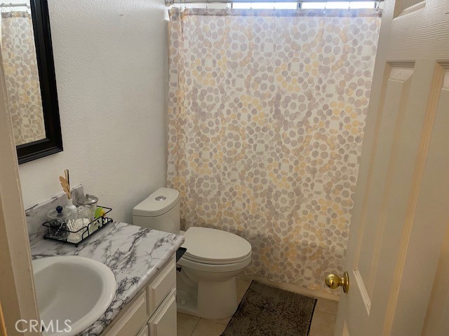 1665 North Fillmore Avenue Rialto, CA 92376 - Photo 13 of 23 a bathroom with a granite countertop toilet and a sink