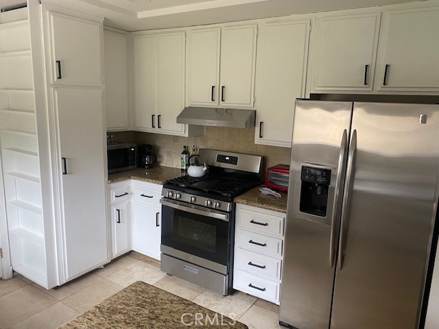 1665 North Fillmore Avenue Rialto, CA 92376 - Photo 5 of 23 a kitchen with stainless steel appliances a stove and a refrigerator