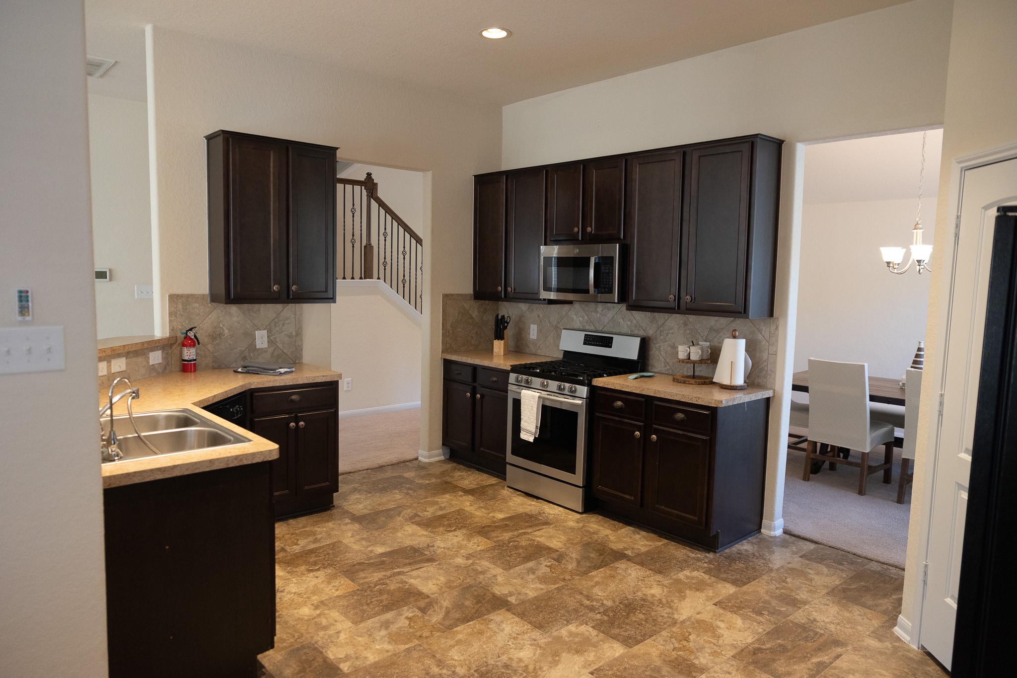 14550 Myers Drive Houston, TX 77090 - Photo 11 of 23 a kitchen with kitchen island granite countertop a sink dishwasher stove and refrigerator with wooden cabinets