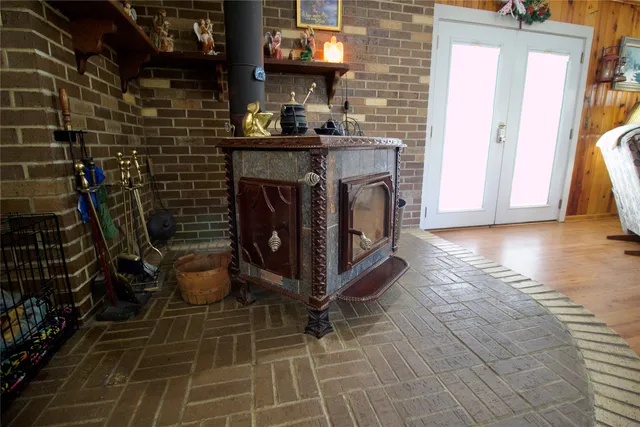 a kitchen with stainless steel appliances kitchen island granite countertop a refrigerator oven a dining table and chairs with wooden floor