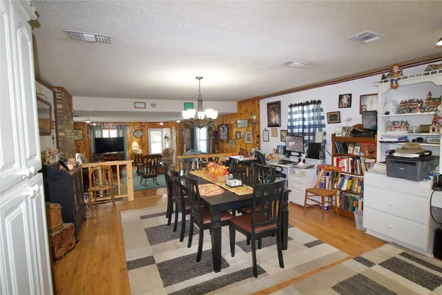 a kitchen that has a lot of cabinets stainless steel appliances and wooden floor